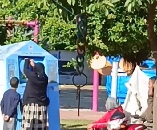 Giysi kumbarasına giren çocuk, topladığı kıyafetleri annesine verdi
