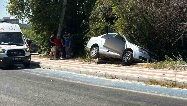 Kaldırıma çıkıp asılı kalan otomobildekiler kazayı burnu bile kanamadan atlattı